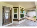 Covered entryway with decorative windows, leading into a home with tiled floors and neutral décor at 2237 Sadnet Ln, North Port, FL 34286