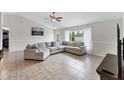 Open-concept living room featuring tile flooring, a large sectional sofa, and bright natural light at 2237 Sadnet Ln, North Port, FL 34286