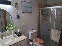 Cozy bathroom featuring a vanity with a sink, toilet, and a glass door shower at 2411 Quail Ct, Bradenton, FL 34209