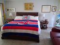 Bright bedroom with a large bed, side tables, and a red couch at 2411 Quail Ct, Bradenton, FL 34209