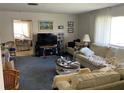 Cozy living room featuring plush seating, a large window for natural light, and neutral carpeting at 2617 Riverbluff Pkwy # V151, Sarasota, FL 34231