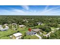 Aerial view of a modern home surrounded by lush greenery in a serene neighborhood at 2692 Pretzel Ln, North Port, FL 34286