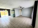 Open-concept living room with tile flooring, ceiling fan and glass sliding door at 3526 Southern W Pkwy, Bradenton, FL 34205