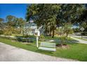 Charming home featuring a bench, mailbox, mature trees, and a well-maintained front lawn at 4410 67Th Avenue E Cir, Sarasota, FL 34243