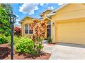 Close-up of home's entrance featuring vibrant flowers, manicured landscaping, and inviting architecture at 5004 Creekside Trl, Sarasota, FL 34243