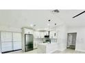 Open-concept kitchen with stainless steel appliances, white cabinetry, granite counters, and stylish pendant lighting at 5009 Jody Ave, North Port, FL 34288