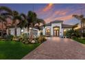 Beautiful home boasting tropical landscaping, stone accents, and a large paver driveway at 5804 Mulligan Way, Lakewood Ranch, FL 34211