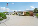 Inviting single-story home with lush landscaping and a spacious driveway, complemented by an American flag at 6002 34Th W Ave, Bradenton, FL 34209