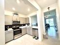 Stylish kitchen with stainless steel appliances and an open view into the living room at 6253 Whetstone Ct, Palmetto, FL 34221