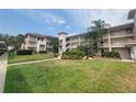 Three-story condo building with balconies, a lush green lawn and mature palm trees at 6507 Stone River Rd # 302, Bradenton, FL 34203