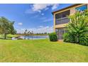 Serene backyard with a screened lanai, expansive lawn, and picturesque pond view at 6512 Grand Estuary Trl # 101, Bradenton, FL 34212