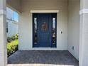 Inviting front entrance with a navy door, sidelights and a decorative wreath at 931 Signet Dr, Apollo Beach, FL 33572