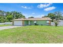 Charming home boasts a lush lawn, complemented by a stone-accented facade and a convenient two-car garage at 9543 Rockhill Rd, Thonotosassa, FL 33592