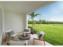 A cozy patio area featuring comfortable seating, a modern fire pit, and a lush green view at 9990 Key Haven Rd, Seminole, FL 33777