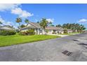 Exterior view of a single-story home with lush lawn, palm trees and a paved driveway at 2417 Fairway Oaks Dr # 22, Palmetto, FL 34221