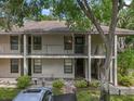 Two-story condo building featuring balconies and landscaping, set in a lush green environment at 3003 Quail Holw # 10, Sarasota, FL 34235