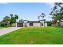 Charming one-story home featuring a modern front door, fresh landscaping, and a well-kept green lawn at 326 Randolph Rd, Venice, FL 34293