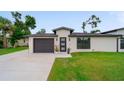 Inviting home exterior with a well-maintained lawn, modern three-panel front door, and a convenient attached garage at 326 Randolph Rd, Venice, FL 34293