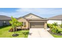 Charming single-story home with a two-car garage, a well-kept lawn, and tropical landscaping at 5327 Olano St, Palmetto, FL 34221