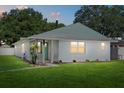 Charming single-story home with a freshly painted exterior and well-manicured lawn at twilight at 5718 Magnolia N St, St Petersburg, FL 33703