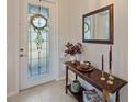 Elegant foyer with decorative table, mirror, and a glass-paneled front door at 8755 Dolomite Ave, North Port, FL 34287