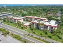 Aerial view of condo buildings surrounded by lush landscaping, mature trees, and a neighborhood at 925 Beach Rd # 408, Sarasota, FL 34242