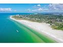 An aerial view showcasing the condo complex with nearby beach access, tropical trees, and ocean views at 925 Beach Rd # 408, Sarasota, FL 34242