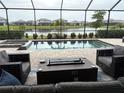 Screened-in backyard with pool, spa, outdoor seating, and a view of the lake at 15437 White Linen Dr, Bradenton, FL 34211