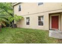 Exterior side view of a home featuring a well-maintained lawn and a red front door at 2303 28Th E Ave, Palmetto, FL 34221