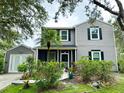 Charming two-story home featuring black shutters, well-maintained landscaping, and an attached garage at 25640 State Road 70 E, Myakka City, FL 34251