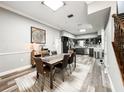 Spacious living room includes a dining room table, hardwood floors and a view of the modern kitchen at 25640 State Road 70 E, Myakka City, FL 34251