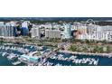 An aerial view showcases a marina filled with boats, surrounded by city buildings on a sunny day at 33 S Palm Ave # 1501, Sarasota, FL 34236
