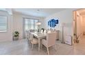Bright dining room with modern chandelier, stylish furniture, and large window at 3419 74Th Avenue E Cir, Sarasota, FL 34243
