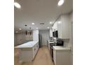 Modern kitchen featuring white cabinets, quartz countertops, a center island, and stainless steel appliances at 4661 Linwood St, Sarasota, FL 34232