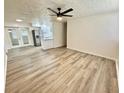 Spacious living room with hardwood floors, modern ceiling fan, and a clear view into the kitchen at 6031 11Th E St, Bradenton, FL 34203