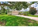 Well-maintained home with lush green lawn, mature shade trees, and a two-car garage at 6644 Butlers Crest Dr, Bradenton, FL 34203
