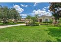 Inviting single-story home with lush green lawn, tropical landscaping, and a paved driveway at 6644 Butlers Crest Dr, Bradenton, FL 34203