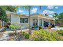 Beautifully landscaped property with modern paint, stone path, mature palm, and a covered parking area at 809 40Th St, Sarasota, FL 34234