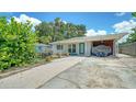 Lovely property featuring stone walkway, small yard, covered parking area, and a light turquoise front door at 809 40Th St, Sarasota, FL 34234