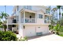 Close up of a charming two-story coastal home with a white exterior, multiple balconies, and a spacious driveway at 9403 9Th Nw Ave, Bradenton, FL 34209