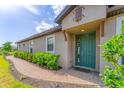 Inviting front entrance with a vibrant blue door, brick walkway, and lush greenery at 3025 Veneto Ct, Bradenton, FL 34211