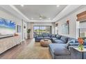 Comfortable living room with a large sectional couch, big windows and a modern TV at 3025 Veneto Ct, Bradenton, FL 34211
