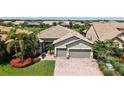 An aerial shot showcases a house with a nicely landscaped yard, complemented by a paver driveway at 11200 Whimbrel Ln, Sarasota, FL 34238