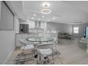 Bright, modern dining area featuring a glass table, sleek white chairs, and an open-concept layout at 1150 Tarpon Center Dr # 1-C 103, Venice, FL 34285