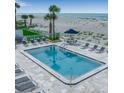 Inviting community pool surrounded by lounge chairs and landscaped grounds with views of the ocean at 1150 Tarpon Center Dr # 1-C 103, Venice, FL 34285