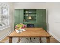 Well-appointed office featuring custom green built-ins, a modern desk, and plush area rug at 12017 Cranston Way, Bradenton, FL 34211