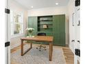 Stylish office with a wooden desk, a comfortable chair, and floor to ceiling built-in shelving at 12017 Cranston Way, Bradenton, FL 34211