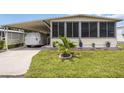 Charming home featuring a covered carport, screened-in porch, and well-manicured lawn with landscaped planters at 170 Edgewood Dr, Osprey, FL 34229