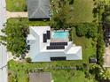 Aerial view of a modern home with a pool, solar panels, and well-manicured lawn at 2460 Hillview St, Sarasota, FL 34239