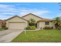 Charming single-story home featuring a well-manicured lawn, lush landscaping, and an attached two-car garage at 2710 93Rd E Ct, Palmetto, FL 34221